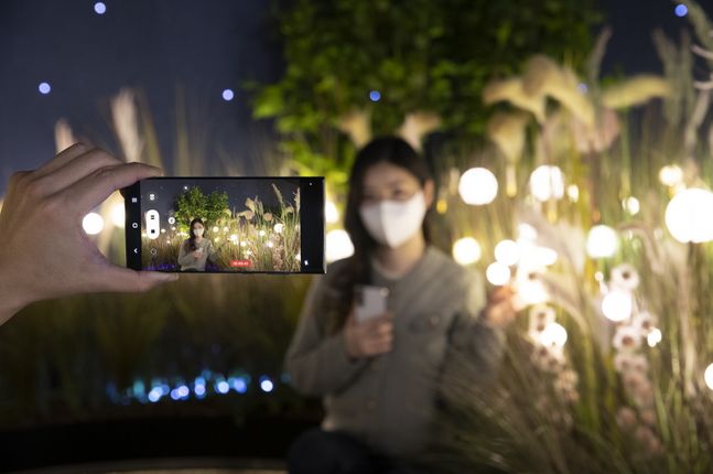 삼성 디지털프라자 홍대본점을 찾은 소비자가 밤의 체험 공간에서 '갤럭시S22 울트라'의 '나이토그래피' 기능으로 야간 동영상 촬영을 하고 있다.ⓒ삼성전자