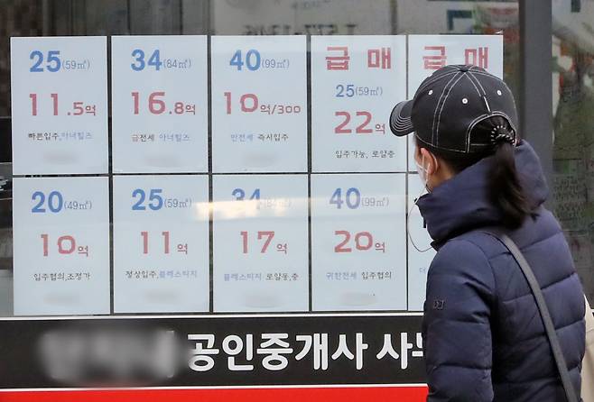 13일 서울시 강남구의 한 부동산 공인중개사 사무소에 붙어진 아파트 매물 가격표 앞으로 시민이 지나가고 있다.  최근 집값 하락의 움직임과 함께 금리 인상으로 전세대출 금리가 빠르게 오르면서 이자에 대한 부담감과 함께 깡통전세를 피해 월세를 찾으려는 세입자들이 늘어나고 있다. 2022.2.13/뉴스1