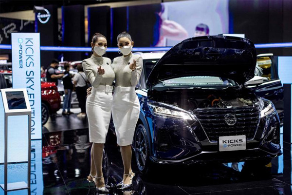 Models pose beside a Nissan Kicks E-Power electric vehicle car at the Thailand International Motor Expo 2021 in Nonthaburi province on Dec 2, 2021. (File photo: AFP)