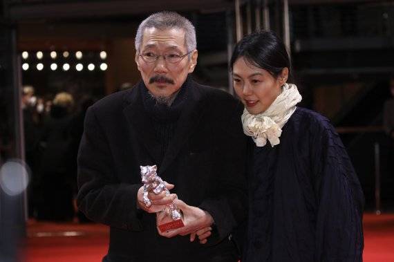 [베를린=AP/뉴시스] 홍상수 감독이 16일(현지시간) 독일 베를린에서 열리고 있는 제72회 베를린 국제영화제 시상식에서 영화 '소설가의 영화'로 은곰상 심사위원대상을 받고 연인인 김민희와 함께 기념촬영을 하고 있다. 2022.02.17. <저작권자ⓒ 공감언론 뉴시스통신사. 무단전재-재배포 금지.> /사진=뉴시스화상