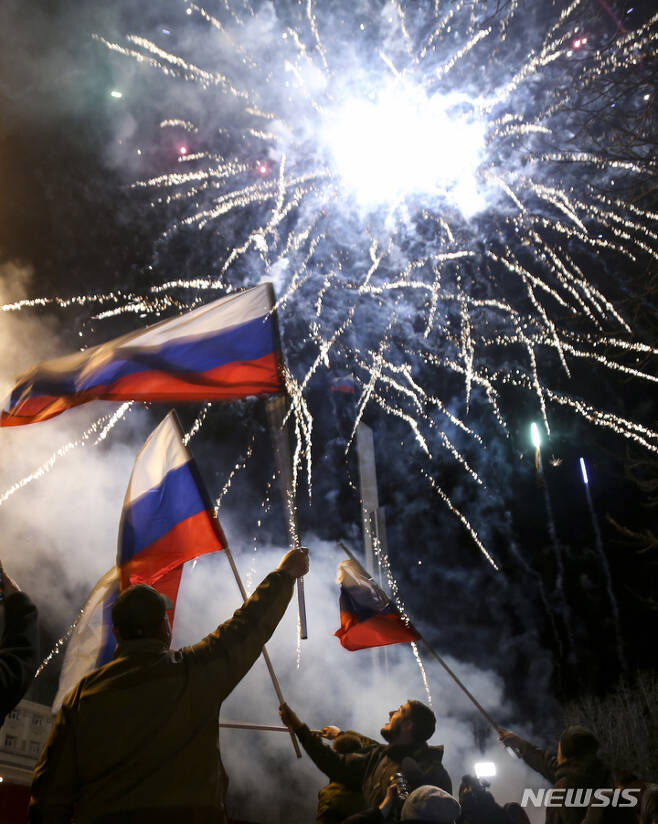 [도네츠크=AP/뉴시스] 21일(현지시간) 우크라이나 동부 친 러시아 반군 지역인 도네츠크 중심가에서 사람들이 러시아 국기를 흔들며 독립을 축하하고 있다. 블라디미르 푸틴 러시아 대통령은 돈바스 지역(도네츠크, 루한스크)의 독립을 승인하면서 이들 지역에 러시아 군대를 파견해  러시아 정부가 '평화유지 활동'을 수행할 것이라고 밝혔다. 2022.02.22.