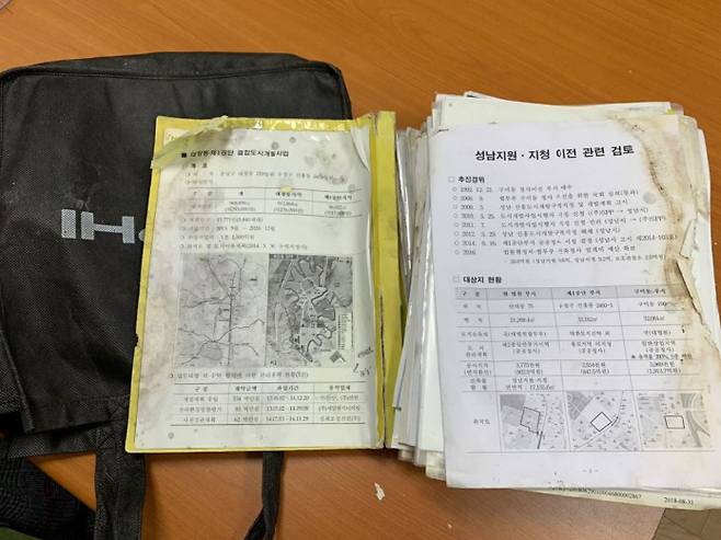 제2경인고속도로 부근 배수로에 버려져 있던 검은색 가방과 대장동 관련 문건. [국민의힘 제공]