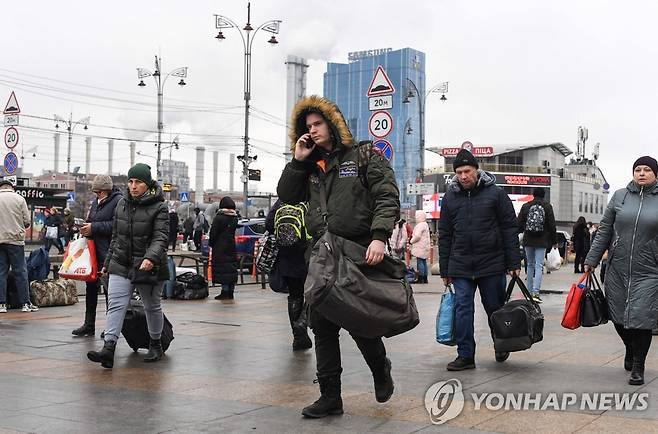 공습경보 발령 속 가방 들고 바삐 걸어가는 키예프 시민들 (키예프 AFP=연합뉴스) 가방을 든 피란 차림의 사람들이 24일 아침(현지시간) 우크라이나 수도 키예프 도심의 키예프-파사지르스키 철도역 인근을 바삐 걸어가고 있다. 블라디미르 푸틴 러시아 대통령이 우크라이나 내의 군사작전을 승인한 이날 키예프 시내에서 공습 사이렌이 울리는 등 우크라이나 전국 곳곳이 러시아군의 미사일 공격과 포격을 받은 것으로 알려졌다. 2022.2.24 alo95@yna.co.kr