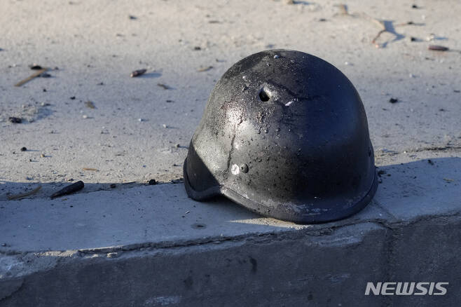[키예프=AP/뉴시스] 지난 26일(현지시간) 우크라이나 키예프 거리 불에 탄 군용 트럭 잔해 근처에 총알구멍이 난 군인의 헬멧이 나뒹굴고 있다. 2022.02.27.