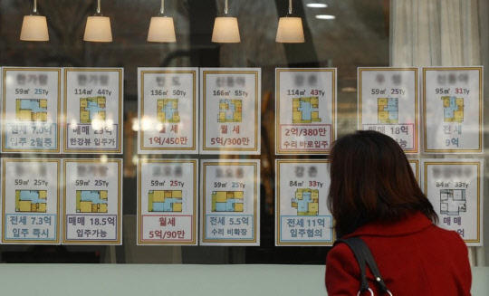 한 시민이 부동산중개업소 매물정보 게시판에 붙어 있는 시세 정보를 살펴보고 있다. <연합뉴스>