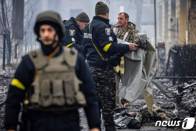 2일(현지시간) 러시아 군의 공습을 받은 우크라이나 키예프의 TV 방송 타워 주변에서 경찰이 행인의 시신을 수습하고 있다. © AFP=뉴스1 © News1 우동명 기자