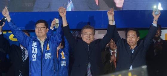 2017년 5월 더불어민주당 대선후보이던 문재인 대통령이 부산 중구 광복중앙로에서 열린 집중유세에서 김영삼 전 대통령의 차남 김현철 당시 국민대 교수, 김대중 전 대통령의 삼남 김홍걸 당시 민주당 국민통합위원장과 손을 들어 인사하고 있다. 뉴시스