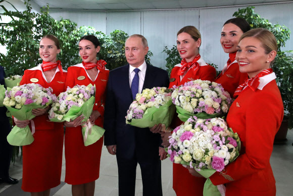 블라디미르 푸틴 러시아 대통령이 5일(현지시간) 국제 여성의 날을 앞두고 모스크바 근교에 있는 국영항공사 아에로플로트 항공학교를 방문해 여승무원들과 기념사진을 찍고 있다.AP 연합뉴스