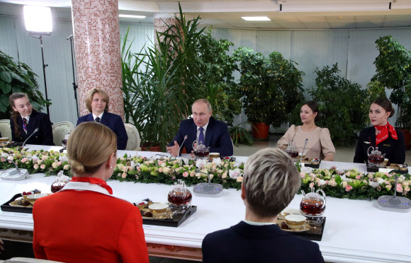블라디미르 푸틴(가운데) 러시아 대통령이 5일(현지시간) 국제 여성의 날을 앞두고 모스크바 근교의 국영 항공사 아에로플로트 항공학교를 방문해 여승무원들과 대화를 나누고 있다.로이터 연합뉴스