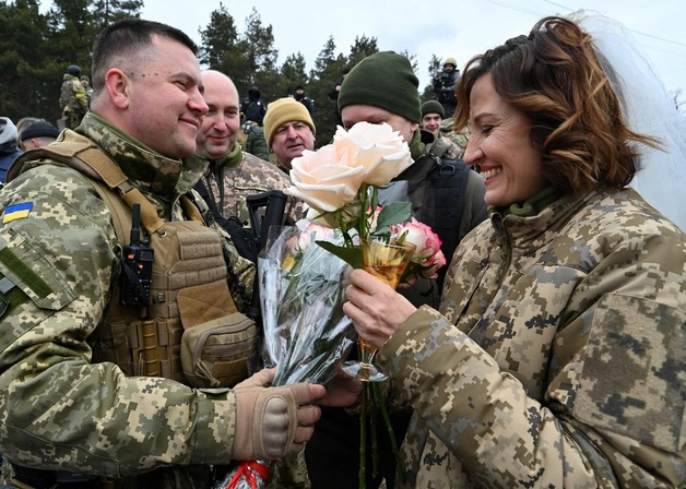 (키이우 AFP=뉴스1) 우동명 기자 = 6일(현지시간) 러시아가 침공한 우크라이나 수도 키이우 검문소에서 군인 부부가 결혼식을 축하 받고 있다.  (C) AFP=뉴스1