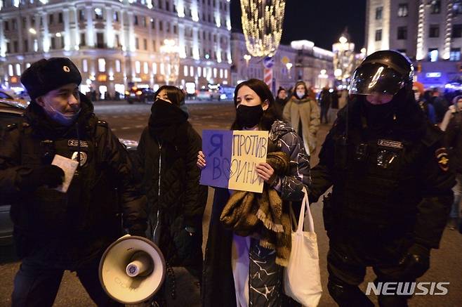 [모스크바=AP/뉴시스] 24일(현지시간) 러시아 모스크바에서 경찰이 "전쟁에 반대합니다"라고 쓴 손팻말을 든 한 시위 참가 여성을 연행하고 있다. 이날 러시아 전역에서 러시아의 우크라이나 침공에 항의하는 시위가 벌어져 모스크바와 상트페테르부르크에서만 1천여 명이 체포됐다. 2022.02.25.