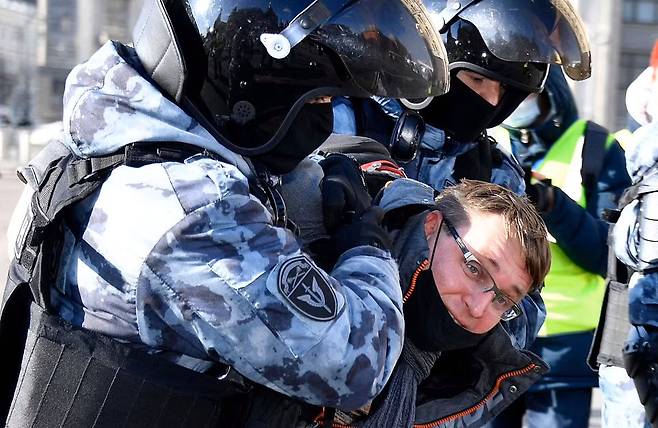 러시아 수도 모스크바의 마네즈나야 광장에서 지난 13일(현지시간) 반전 시위에 참가한 한 남성이 2명의 경찰에게 연행되고 있다.(사진=AFP 연합뉴스)