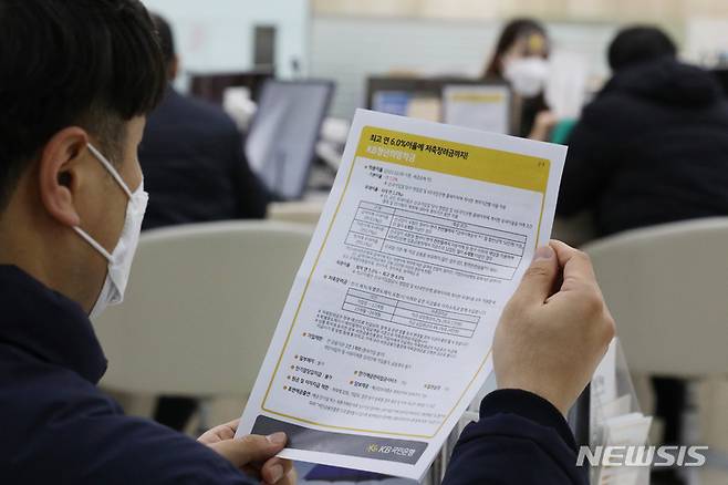 [서울=뉴시스] 조수정 기자 = 연 최고 10%대 금리가 적용되는 청년희망적금이 출시된 21일 서울 영등포구 국민은행 여의도영업부점에서 한 내방객이 안내문을 보고 있다. 청년희망적금은 가입일 기준 만19세에서 34세가 신청 가능하다. 국민·기업·농협·신한·우리·하나·광주·대구·부산·전북·제주은행에서 대면 및 비대면으로 진행된다. 출시 첫주인 이날부터 25일까지는 5부제를 적용한다. 이날은 91·96·01년생이 신청할 수 있다. 2022.02.21. chocrystal@newsis.com