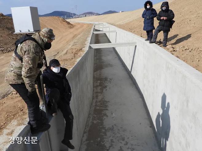 전문가들과 시민단체 회원 등이 지난달 17일 경기 파주시 공릉천 하류의 하천정비사업 공사로 조성된 수로를 살펴보고 있다. 전문가들은 이 수로가 개구리 등 양서류는 물론 포유류, 파충류 등 다양한 생물들이 빠진 뒤 탈출하지 못하는 무덤이 될 것으로 우려하고 있다. 시민탐조클럽 제공.