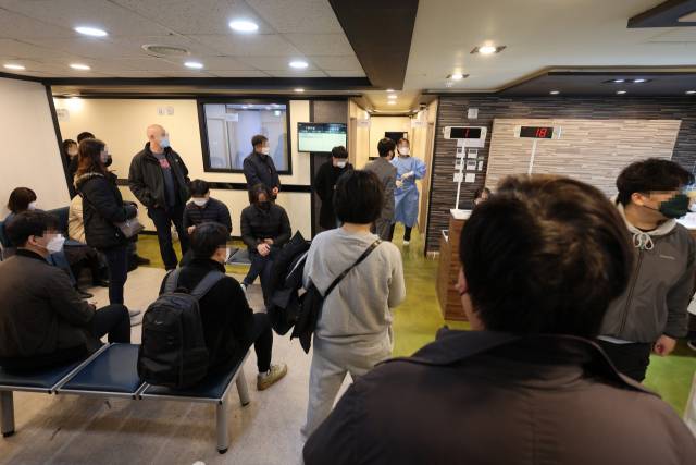 지난 18일 오전 서울 시내의 한 이비인후과에서 코로나19 전문가용 신속항원검사를 하기 위해 피검자들이 대기하고 있다. 연합뉴스