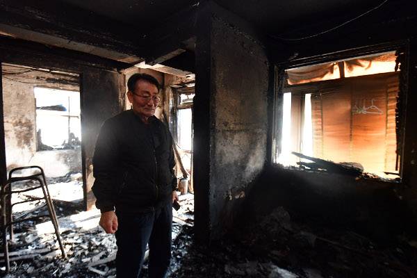 허탈한 표정으로 전소된 집을 보고 있는 울진군 검성리의 이재민 온성기씨.
