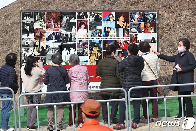 박근혜 전 대통령 귀향과 입주를 하루 앞둔 23일 오후 지지자들이 사저 앞 게시대에 전시된 박 전 대통령 사진을 살펴보고 있다. 2022.3.23/뉴스1 © News1 공정식 기자