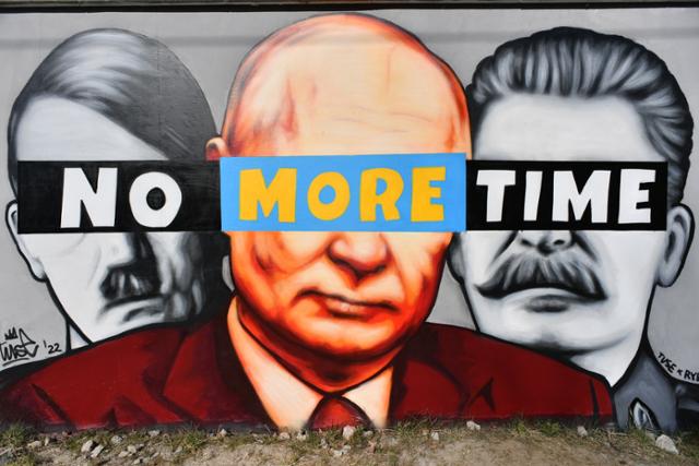 폴란드 북부 그단스크 거리의 한 벽에 22일 아돌프 히틀러(맨 왼쪽부터)독일 독재자와 블라디미르 푸틴 러시아 대통령, 이오시프 스탈린 소련 공산당 서기장의 얼굴이 그려져 있고 그 위로 '시간이 없다'는 문구가 적혀 있다. 그단스크=EPA 연합뉴스