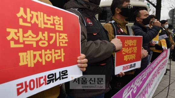 23일 오전 서울 종로구 통의동 대통령직 인수위원회 입구 인도에서 라이더유니온 주최로 열린 특수형태 근로종사자 산재보험 전속성 폐지 요구 회견에서 참석자들이 피켓을 들고 있다. 이날 회견 참석자들은 배달 종사자 등 특수행태 근로자들이 산재보험 적용을 못받는 경우가 많다며,  5월 새롭게 출범할 새정부에 대책 마련을 촉구했다. 2022.3.23 박지환기자