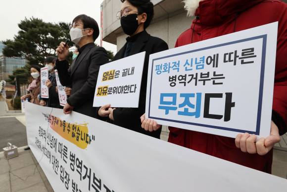 지난 2021년 2월25일 서울 서초구 대법원 동문 앞에서 열린 평화적 신념에 따른 병역거부자 대법원 선고에 대한 입장 발표 기자회견에서 참석자들이 손팻말을 들고 있다. ⓒ연합뉴스