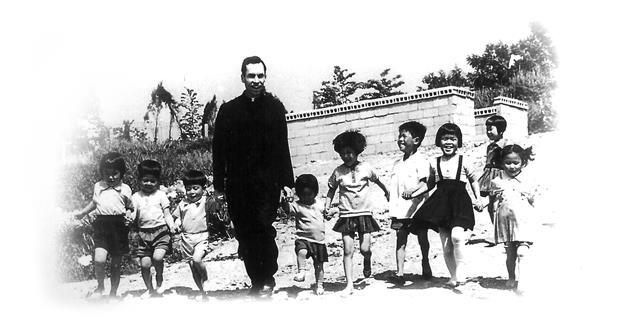 아이들과 함께 손잡고 웃고 있는 소 알로이시오 신부의 생전 모습.알로이시오 기지 1968 제공