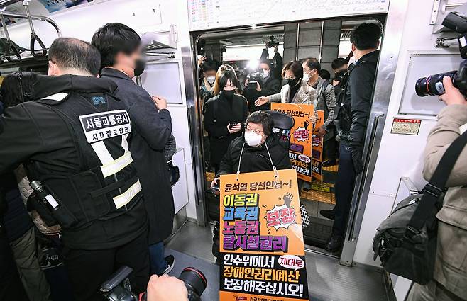 전국장애인차별철폐연대(전장연) 회원들이 28일 서울 종로구 경복궁역 3호선에서 장애인 이동권 보장·장애인 권리 보장 예산 반영을 요구하기 위해 열린 지하철 시위 ‘출근길 지하철 탑니다’를 위해 전동차에 탑승하고 있다. 2022.3.28 연합뉴스