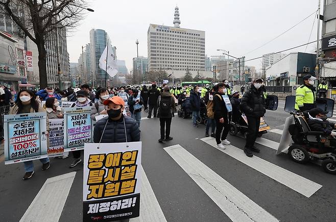 사진은 장애인 단체 회원들이 지난 25일 오전 서울 종로구 지하철 3호선 경복궁역 부근에서 대통령직인수위원회에 장애인 이동권, 교육권, 노동권, 탈시설 권리, 장애인권리예산 보장 등을 촉구하며 행진하고 있는 모습. 2022.3.25 연합뉴스