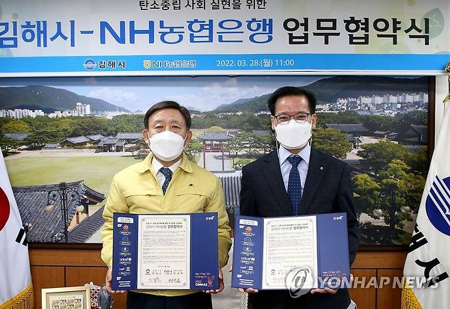 김해시·NH농협 탄소중립 한뜻 (김해=연합뉴스) 경남 김해시와 NH농협은행이 28일 탄소포인트제 가입 김해시민에게 우대금리 등 적용을 골자로 하는 탄소중립사회 실현 업무협약을 했다. 허성곤 김해시장(왼쪽)과 박삼재 NH농협 김해시지부장이 협약서에 사인한 후 기념촬영을 하고 있다.
 2022.3.28 [김해시 제공. 재판매 및 DB 금지] seaman@yna.co.kr