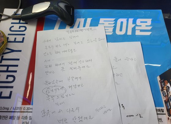 보이스피싱 피해를 예방한 편의점주 홍모씨와 피해자 A씨가 사건 당시 A4용지로 나눈 필담 내용. A씨는 종이에 ″아들이 납치를 당해서 돈 요구하는대로 보내고 있는 중″이라고 적었다. 양수민 기자