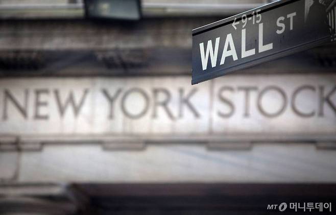 A Wall Street sign is pictured outside the New York Stock Exchange in New York, October 28, 2013. REUTERS/Carlo Allegri/File Photo