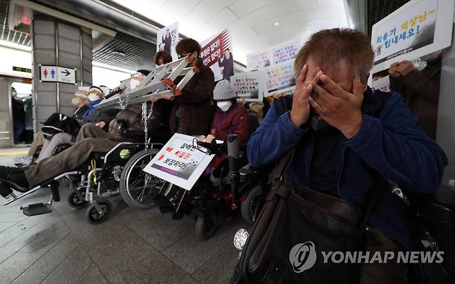 3월 31일 오전 서울 경복궁역에서 전국장애인차별철폐연대가 연 '제2차 삭발 투쟁 결의식'에서 한 참가자가 최용기 한국장애인자립생활센터협의회 회장의 발언을 들으며 눈물을 흘리고 있는 모습 [연합뉴스 자료사진]