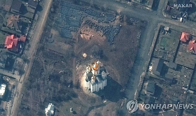 위성에 찍힌 우크라 민간인 시신 집단매장 터 (부차 AFP=연합뉴스) 우크라이나 수도 키이우(키예프) 북부 소도시 부차의 한 교회 앞마당에서 위성으로 촬영된 민간인 희생자 집단매장 터 모습. 미국 민간위성업체 맥사 테크놀로지스가 지난달 31일(현지시간) 찍어 3일 공개한 이 사진 윗부분에 길이 약 14m에 달하는 구덩이가 선명하게 보인다. 우크라이나 당국은 최다 300구의 민간인 시신이 포대에 든 채 이 안에 쌓여 있다고 밝혔다. [맥사 테크놀로지스 제공. 판매·광고 금지] 2022.4.4. sungok@yna.co.kr
