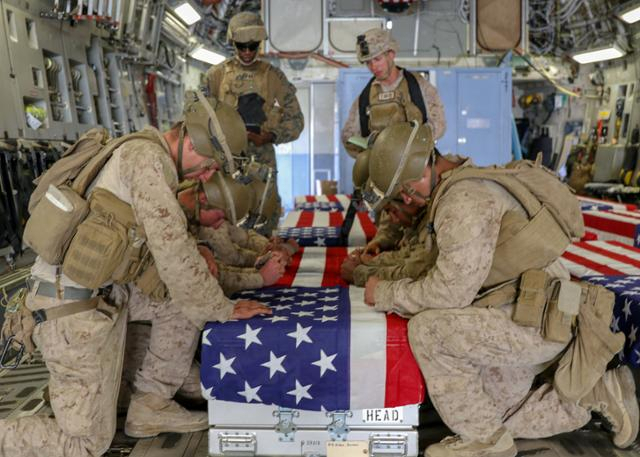 ▲아프가니스탄 수도 카불 하미드 카르자이 국제공항에서 철군하는 과정에서 자살폭탄테러로 전사한 미군의 관을 미국 해병대원들이 수송기 안으로 운구한 뒤 고인의 넋을 기리고 있다. ⓒ로이터-연합뉴스