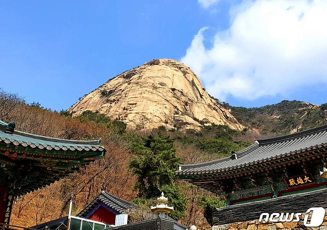 노적사와 노적봉. 거대한 노적봉의 수직 암벽에 암벽등반을 즐기는 사람들이 개미처럼 붙어 있다 © 뉴스1