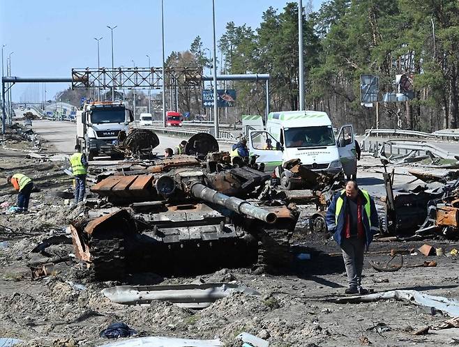 러시아 대통령궁 대변인이 러시아군이 상당한 손실을 입었다고 인정한 7일(현지시각) 우크라이나 수도 키이우 인근 도로에서 파괴된 러시아군 탱크를 치우는 작업이 벌어지고 있다. 키이우/AFP 연합뉴스