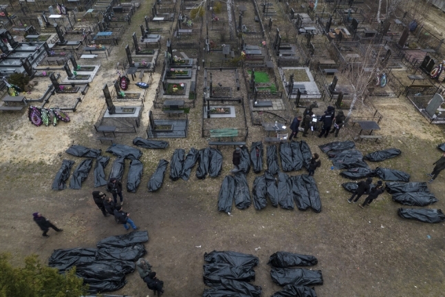 우크라이나 수도 키이우 북서부에 있는 도시 부차의 묘지에서 경찰관들이 학살당한 민간인들의 시신을 놓고 신원을 확인하는 작업을 하고 있다. 부차/AP 연합뉴스