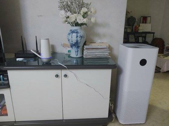 아파트 거실에 미세먼지와 휘발성 유기화합물 등 대기 오염물질 농도를 측정하는 장치(왼쪽)와 공기청정기가 설치돼 있다. [중앙포토]