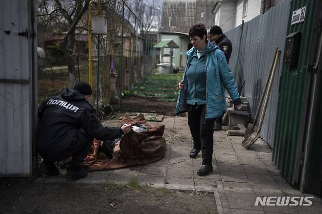 [부차=AP/뉴시스] 11일(현지시간) 우크라이나 키이우 외곽 부차에서 경찰관이 거리에 놓인 주민의 시신을 학인하고 있다. 2022.04.12.