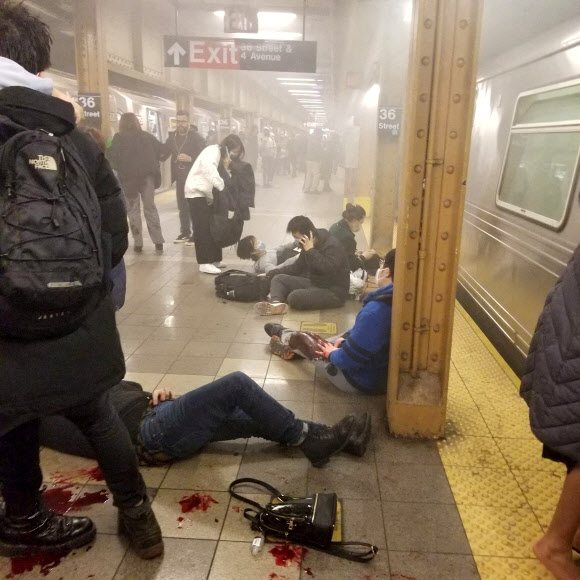 한 흑인 남성이 12일(현지시간) 오전 8시 30분쯤 미국 뉴욕 맨해튼 방면으로 향하는 지하철 객차 안에서 연막탄을 터뜨린 후 총기를 난사하는 사건이 발생했다. 다친 시민들이 브루클린 선셋파크의 36번가역 승강장에서 구조를 기다리고 있다.뉴욕 로이터 연합뉴스