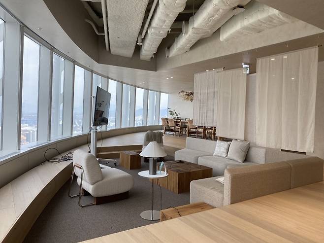 우아한형제들 잠실롯데타워 '더큰집'. 편안한 소파와 화상 회의, 프레젠테이션이 가능한 모니터가 눈에 배치돼있다. [우아한형제들 제공]