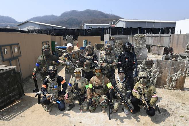 이날 모인 10명의 에어소프트 게임 동호인들이 게임장에서 포즈를 취하고 있다. 게임을 준비하며 대화를 나누던 화기애애한 모습과 달리 게임장에 들어선 동호인들의 표정이 사뭇 진지하다.