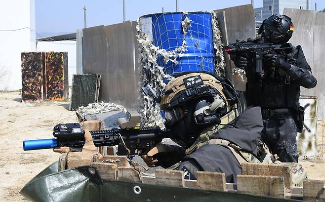 은폐물에 숨은 에어소프트 게임 동호인들이 상대방의 움직임을 살펴보고 있다.