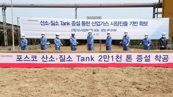 Posco employees including Yoon Duk-il, center, head of the company’s management and planning division, take part in a groundbreaking ceremony for the construction of oxygen and nitrogen storage tanks at its Pohang steel mill on April 27. [POSCO]