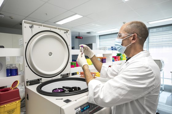 호주 시드니에 있는 임상 전문 기업 사이언티아(Scientia)에서 연구자가 원심분리기 내 샘플을 살피고 있다.