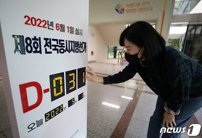 제8회 전국동시지방선거를 한달 앞둔 1일 오전 경기 과천 중앙선거관리위원회 로비에서 관계자가 지방선거 디데이 알림판을 교체하고 있다. 2022.5.1/뉴스1 © News1 이동해 기자