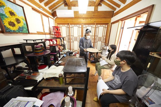 이종구(왼쪽) 작가가 김예람·김하윤 학생기자에게 다양한 종류의 소반을 보여주며 설명했다.
