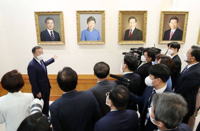 문재인 대통령이 3일 청와대 본관 세종실에서 열린 마지막 국무회의에 앞서 열린 사전환담에서 국무위원들과  역대 대통령 초상화와 함께 걸린 문 대통령의 초상화를 보며 대화하고 있다. 연합뉴스