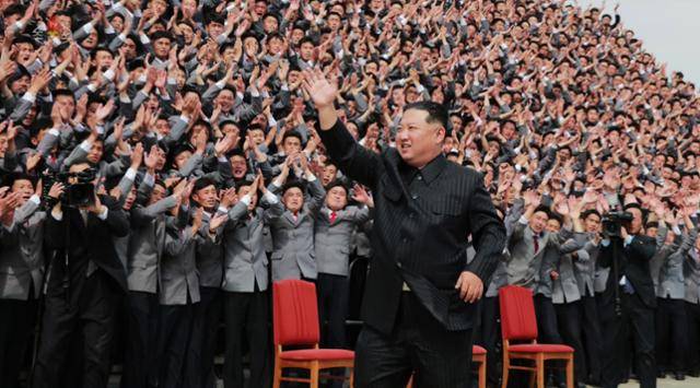 김정은 북한 국무위원장이 1일 지난달 25일 열린 조선인민혁명군 창건 90주년 기념 열병식에 기여한 평양의 대학생 및 근로청년들과 기념사진을 찍으면서 군중의 환호에 손을 들어 답례하고 있다. 조선중앙TV 캡처 뉴시스