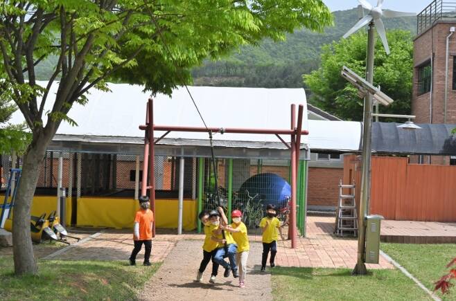 경천애인마을 운동장에서 초등학교 2학년 아이들이 짚라인을 타고 있다.