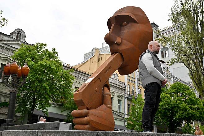 우크라이나인 예술가 드미트로 이우는 7일(현지시간) 우크라이나 수도 키이우 흐레샤티크 거리에 자신이 만든 푸틴 대통령의 조형물을 설치해 사람들 앞에 공개했다. / AFP 연합뉴스